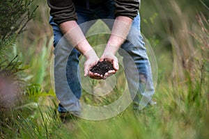 farmer collecting soil samples in a test tube in a field. Agronomist checking soil carbon and plant health on a farm. soil science