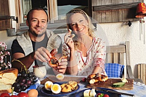 Farmer couple sitting for a snack on a wooden table