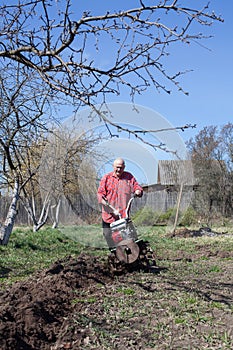 Farmer with   cultivator working in   village