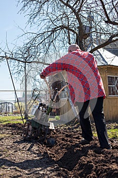 Farmer with   cultivator working in   village