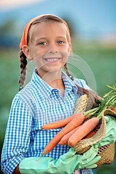 Farmer. Cute little girl holding carrots