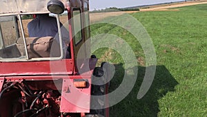 Farmer drive red old tractor between farm rural fields