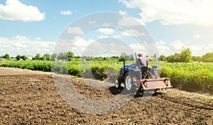 Farmer drives a tractor with a milling machine. Loosening surface, cultivating the land. Farming, agriculture. Loosens, grind and