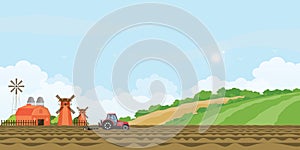 Farmer driving a tractor in farmed land and farmhouse