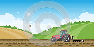 Farmer driving a tractor in farmed land on rural farm landscape hill background