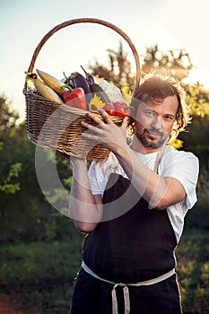 Farmer with an ecological harvest of vegetables in a basket near