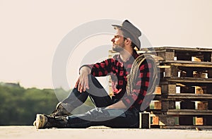 Farmer enjoy view from his farm. Romanticism of western culture. Farmer in hat sit relax. Peaceful mood. Watching sunset