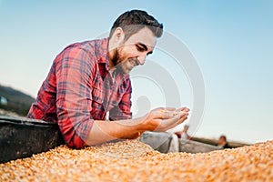 farmer, farm worker looking at corn harvest in tractor trailer