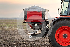 Farmer fertilizing arable land with nitrogen fertilizer