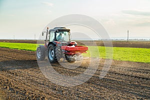 Farmer fertilizing arable land with nitrogen, phosphorus, potassium fertilizer