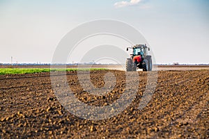 Farmer fertilizing arable land with nitrogen, phosphorus, potassium fertilizer