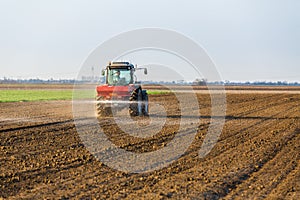 Farmer fertilizing arable land with nitrogen, phosphorus, potassium fertilizer