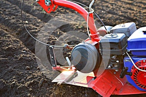 Farmer in a field with rototiller , tiller tractor photo