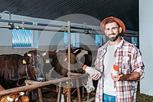 Farmer with fresh milk in stall