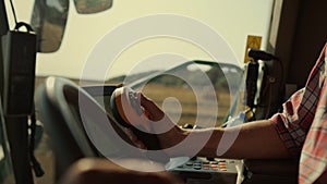 Farmer hands driving harvester closeup. Tractor operator controlling machinery