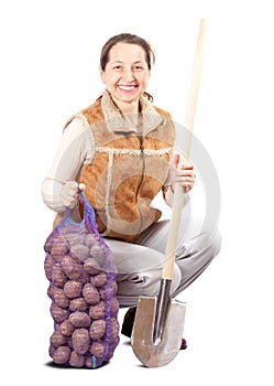 Farmer with harvested potatoes and spade