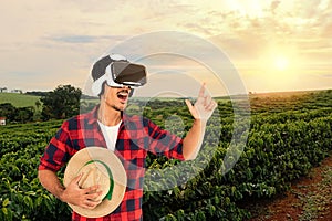 Farmer with hat and virtual reality glasses on coffee plantation landscape