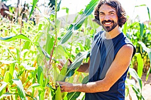 Farmer in his thirties picking corn on a field