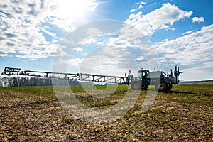 farmer and his tractor equip with a sprayer working in spring