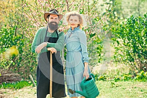 A farmer and his wife standing in their field. Crop planting at fields. Farmars couple enjoy spring nature and take care