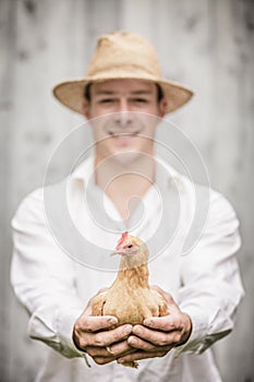 Farmer Holding a Beige Chicken