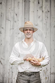 Farmer Holding a Beige Chicken