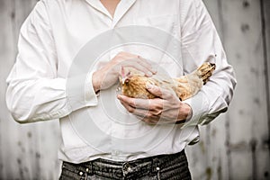 Farmer Holding a Beige Chicken photo