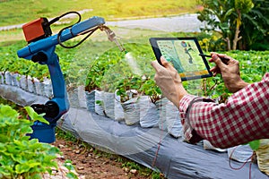 Farmer holding a tablet smart arm robot work agricultural machinery