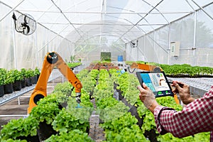 Farmer holding a tablet smart robotic harvest in agriculture futuristic robot automation to work technology increase