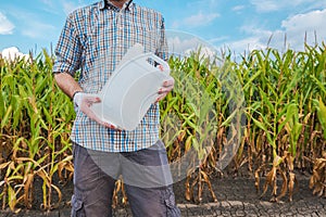 Farmer holding unlabeled pesticide jug in field