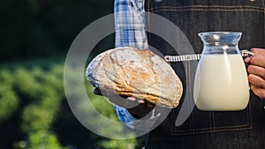 Farmer holds bread and a jug of milk