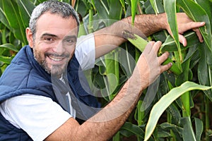 Farmer kneeling by crop