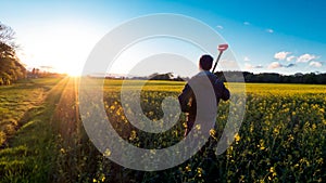 Farmer looking at Rapeseed Flower Field