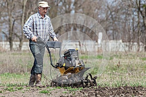 Farmer loosens the soil cultivator