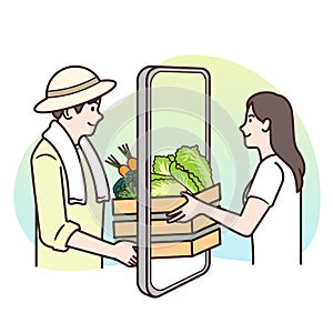 A farmer man wearing a hat on his head is delivering a wooden crate with vegetables inside to a woman who orders online via