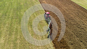 Farmer on a modern tractor cultivates the soil with a multi-field revolving plow