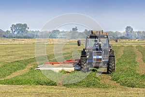 Farmer mowing the grass using a tractor with a mower