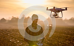 Farmer navigating drone above farmland