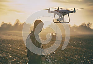 Farmer navigating drone above farmland