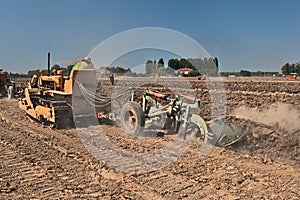 Farmer plowing the field with an old crawler tractor Fiat