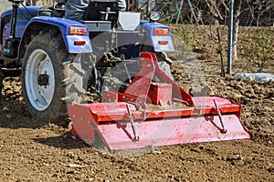 Farmer plows the field. Small tractor with a plow in the field. Cultivation