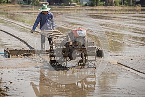 Farmer plowman using tiller tractor