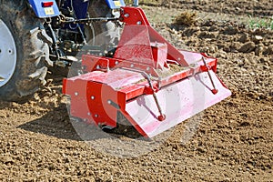 Farmer plows the field. Small tractor with a plow in the field. Cultivation