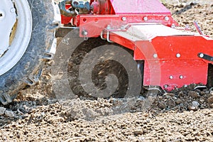 Farmer plows the field. Small tractor with a plow in the field. Cultivation