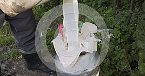 Farmer pours milk through a strainer, a way to purify milk