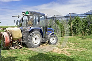 Farmer Preparing Tractor for Orchard Spraying in Springtime