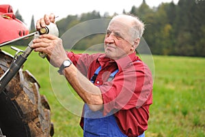 Farmer repairing his red tractor