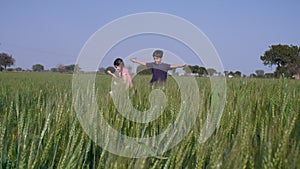 A farmer`s adorable son and daughter running and playing in the agricultural field