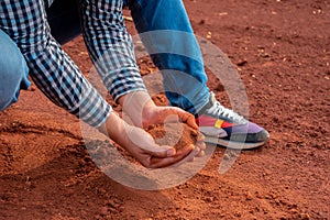 Farmer's hands, calloused and experienced, gently hold the soil, embodying a profound connection to the earth