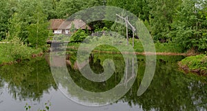 Farmer's house reflecting in a pond in open air museum, Kiev, Ukraine photo